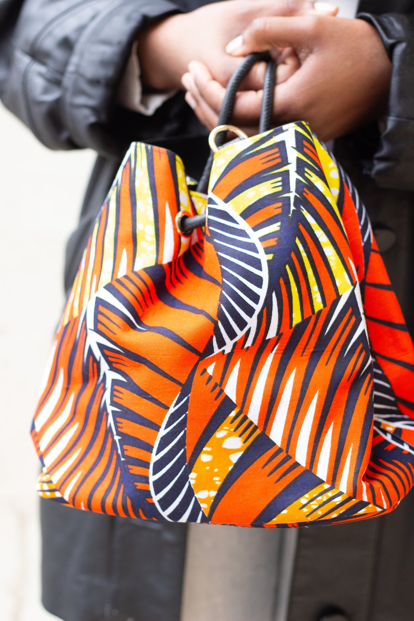Sac seau en Wax : Élégance Africaine et Praticité Moderne Orange jaune noir blanc